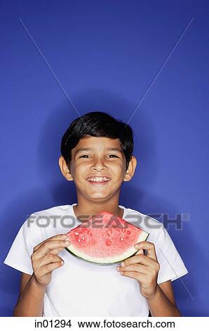 Boy looking at camera, holding watermelon slice View Large Photo Image Picture - Boy looking at camera, holding watermelon slice. Fotosearch