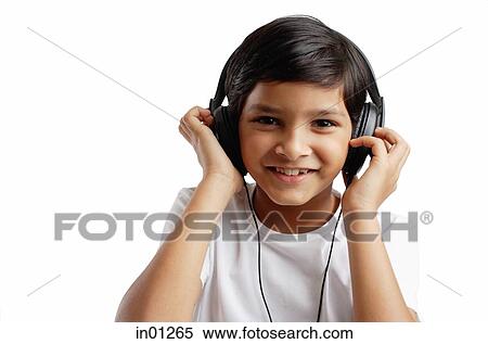 Stock Photography - Boy looking at camera, wearing headphones. Fotosearch