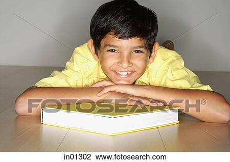 Boy lying on floor, leaning on book View Large Photo Image Stock Image - Boy lying on floor, leaning on book. Fotosearch