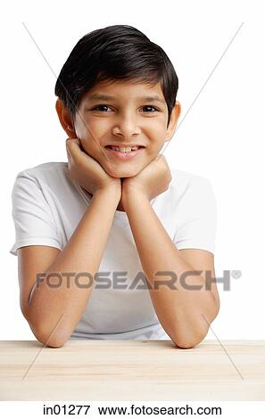 Stock Photo - Boy with hands on chin, smiling. Fotosearch