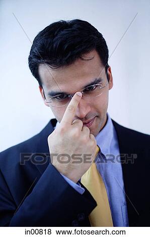 Stock Photo -  Businessman adjusting glasses with finger. Fotosearch