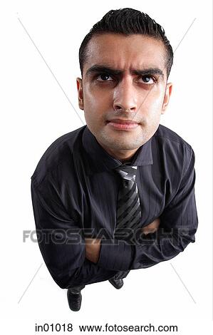 Stock Photo - Businessman, arms crossed, frowning. Fotosearch