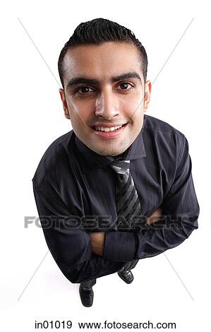 Businessman, arms crossed, looking up at camera, smiling View Large Photo Image Stock Photo - Businessman, arms crossed, looking up at camera, smiling. Fotosearch