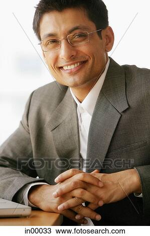 Businessman, hands clasped, looking at camera View Large Photo Image Stock Image - Businessman, hands clasped, looking at camera. Fotosearch
