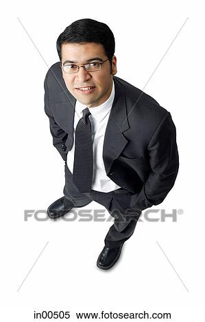 Businessman, hands in pocket, looking up at camera View Large Photo Image Stock Photography - Businessman, hands in pocket, looking up at camera. Fotosearch