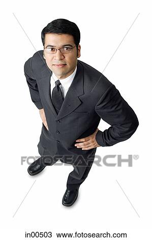 Businessman, hands on waist, looking up at camera View Large Photo Image Stock Image - Businessman, hands on waist, looking up at camera. Fotosearch