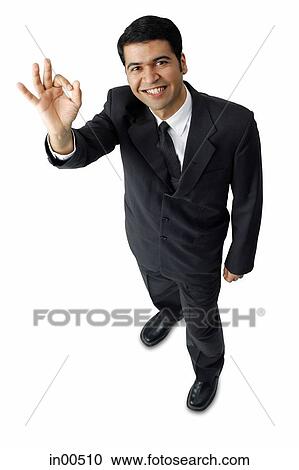 Stock Image - Businessman, hands raised, making hand sign. Fotosearch