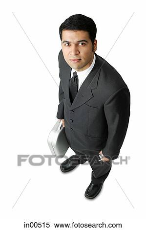 Businessman, holding mobile phone and briefcase, looking up at camera View Large Photo Image Stock Photography - Businessman, holding mobile phone and briefcase, looking up at camera. Fotosearch