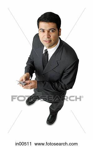 Businessman, holding mobile phone, looking at camera View Large Photo Image Stock Image - Businessman, holding mobile phone, looking at camera. Fotosearch