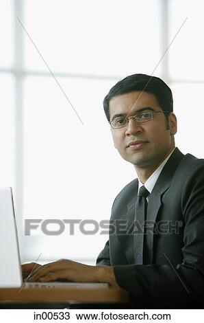 Businessman in office, sitting, looking at camera View Large Photo Image Stock Image - Businessman in office, sitting, looking at camera. Fotosearch