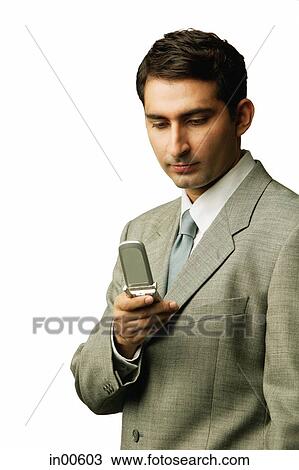 Businessman looking at mobile phone View Large Photo Image Stock Image - Businessman looking at mobile phone. Fotosearch