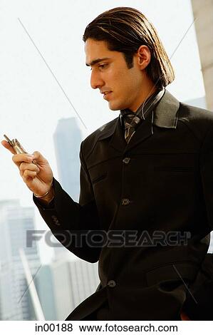 Stock Photo - Businessman looking at mobile phone. Fotosearch