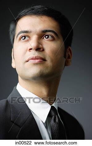 Stock Image - Businessman looking away, portrait. Fotosearch