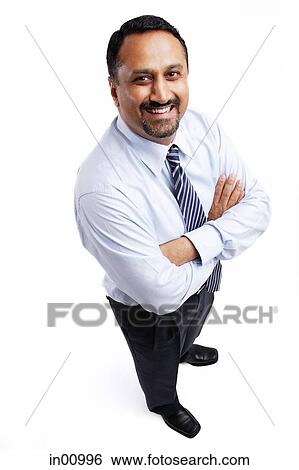 Businessman looking up at camera, arms crossed View Large Photo Image Stock Photograph - Businessman looking up at camera, arms crossed. Fotosearch