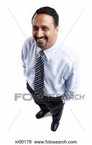Businessman looking up at camera, hands in pocket View Large Photo Image Stock Photo - Businessman looking up at camera, hands in pocket. Fotosearch