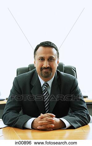 Businessman sitting at desk View Large Photo Image Stock Photograph - Businessman sitting at desk. Fotosearch