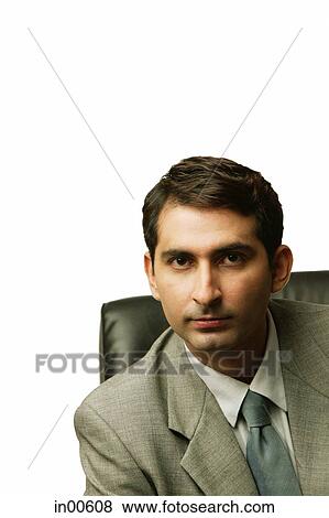 Businessman sitting, looking at camera View Large Photo Image Stock Photo - Businessman sitting, looking at camera. Fotosearch