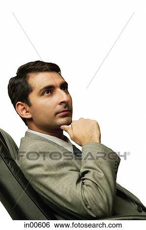 Businessman sitting on chair, hand on chin, away View Large Photo Image Stock Photograph - Businessman sitting on chair, hand on chin, away. Fotosearch