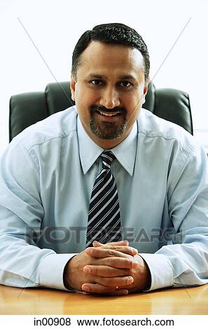 Stock Photo - Businessman sitting, smiling at camera, portrait. Fotosearch