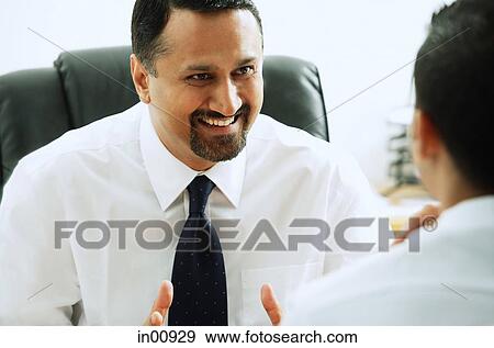 Businessman smiling at person in front of him View Large Photo Image Stock Photo - Businessman smiling at person in front of him. Fotosearch