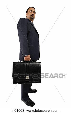 Stock Photo - Businessman standing and holding briefcase. Fotosearch