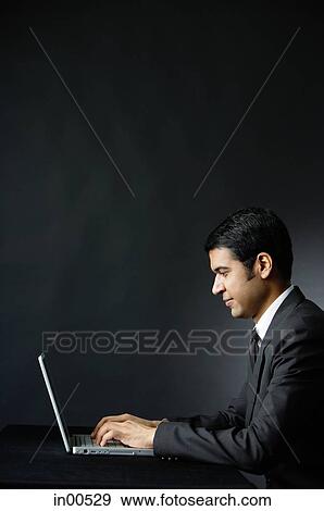 Stock Photo - Businessman using laptop, portrait. Fotosearch