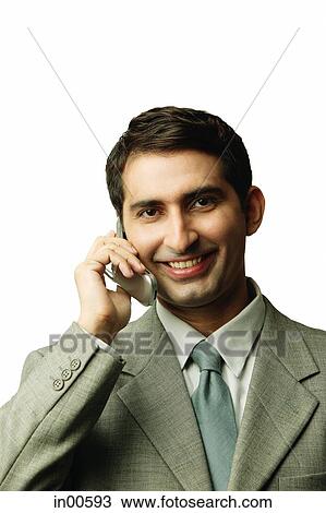 Stock Image - Businessman using mobile phone, facing camera. Fotosearch