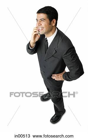 Stock Image - Businessman, using mobile phone, hand on hip. Fotosearch