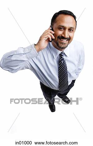 Businessman using mobile phone, looking at camera View Large Photo Image Stock Image - Businessman using mobile phone, looking at camera. Fotosearch