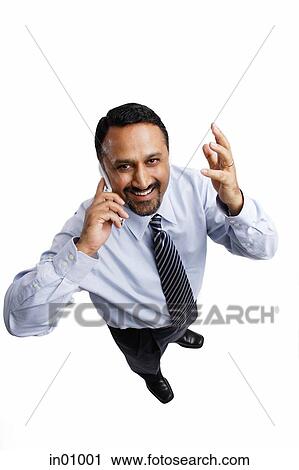 Businessman using mobile phone, looking at camera, hand raised View Large Photo Image Stock Image - Businessman using mobile phone, looking at camera, hand raised. Fotosearch