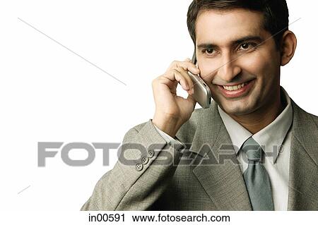 Stock Image - Businessman using mobile phone, smiling. Fotosearch