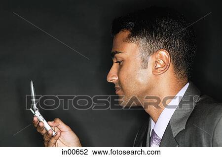 Stock Image - Businessman using mobile phone, text messaging. Fotosearch