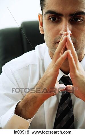 Businessman with hands together, looking away View Large Photo Image Stock Photo - Businessman with hands together, looking away. Fotosearch