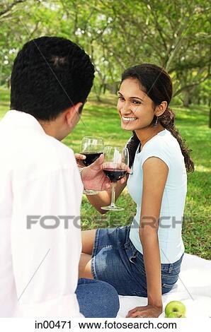 Couple having a picnic, toasting with wine glasses View Large Photo Image Stock Image - Couple having a picnic, toasting with wine glasses. Fotosearch