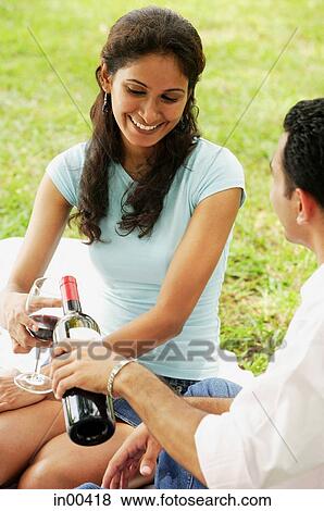 Couple having wine at park View Large Photo Image Stock Photo - Couple having wine at park. Fotosearch
