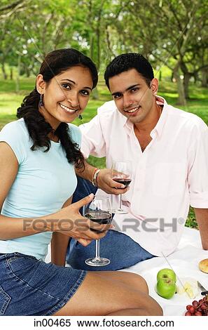 Stock Photography - Couple holding wine glasses, looking at camera, portrait. Fotosearch