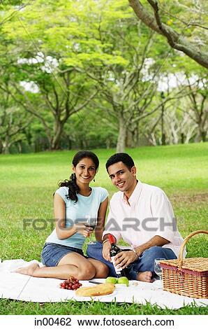 Couple in park, having a picnic, looking at camera View Large Photo Image Stock Image - Couple in park, having a picnic, looking at camera. Fotosearch