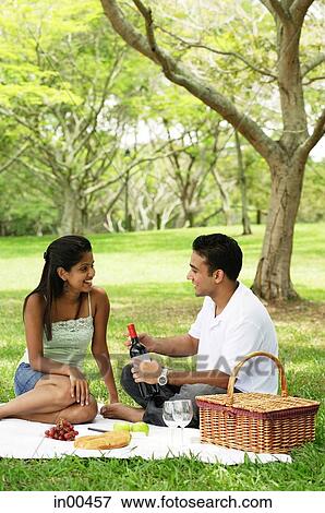 Couple in park, having a picnic View Large Photo Image Stock Photo - Couple in park, having a picnic. Fotosearch