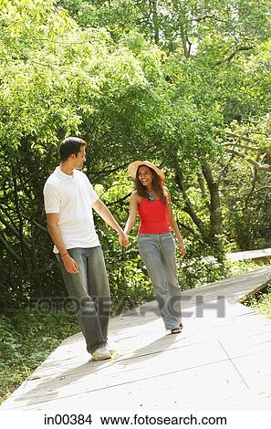 Couple in park, holding hands and walking View Large Photo Image Picture - Couple in park, holding hands and walking. Fotosearch