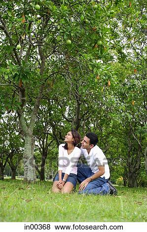 Couple in park, sitting, both looking away View Large Photo Image Stock Photo - Couple in park, sitting, both looking away. Fotosearch