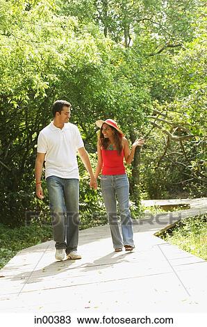 Couple in park, walking, holding hands View Large Photo Image Stock Image - Couple in park, walking, holding hands. Fotosearch