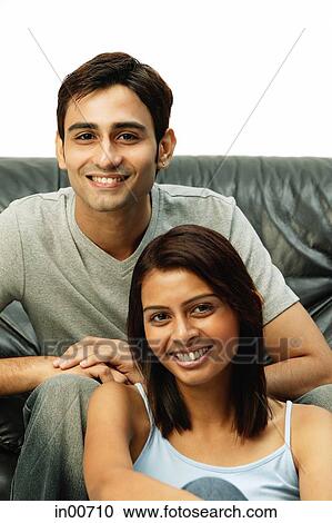 Stock Image - Couple looking at camera, man behind woman. Fotosearch