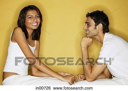 Couple sitting face to face, woman looking at camera, man looking at her View Large Photo Image Stock Photograph - Couple sitting face to face, woman looking at camera, man looking at her. Fotosearch