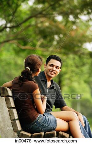 Couple sitting on bench, talking View Large Photo Image Stock Photo - Couple sitting on bench, talking. Fotosearch