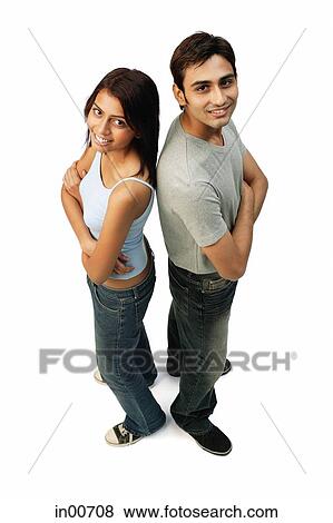 Couple standing back to back, looking at camera View Large Photo Image Stock Photo - Couple standing back to back, looking at camera. Fotosearch