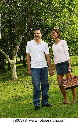 Couple standing in park, holding hands View Large Photo Image Stock Photo - Couple standing in park, holding hands. Fotosearch