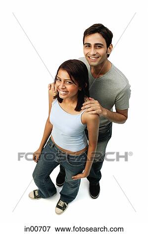 Stock Photo - Couple standing, looking at camera. Fotosearch