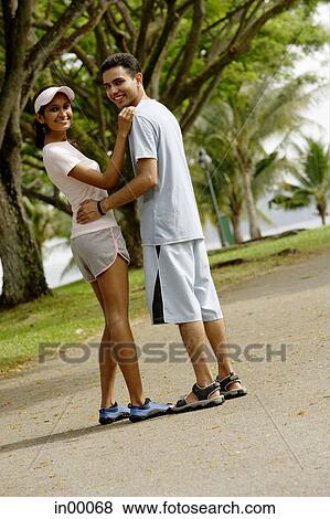 Couple standing, looking over shoulder View Large Photo Image Stock Photo - Couple standing, looking over shoulder. Fotosearch