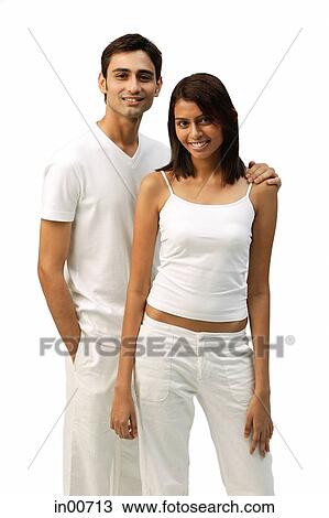 Stock Image - Couple standing side by side, looking at camera. Fotosearch