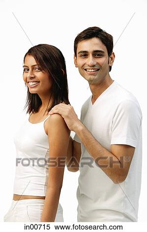 Stock Photography - Couple standing sideways, side by side, looking at camera. Fotosearch